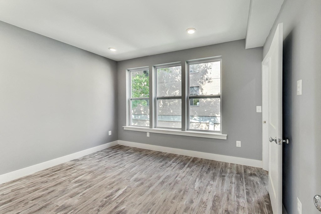the living room of a new home with grey walls and a window