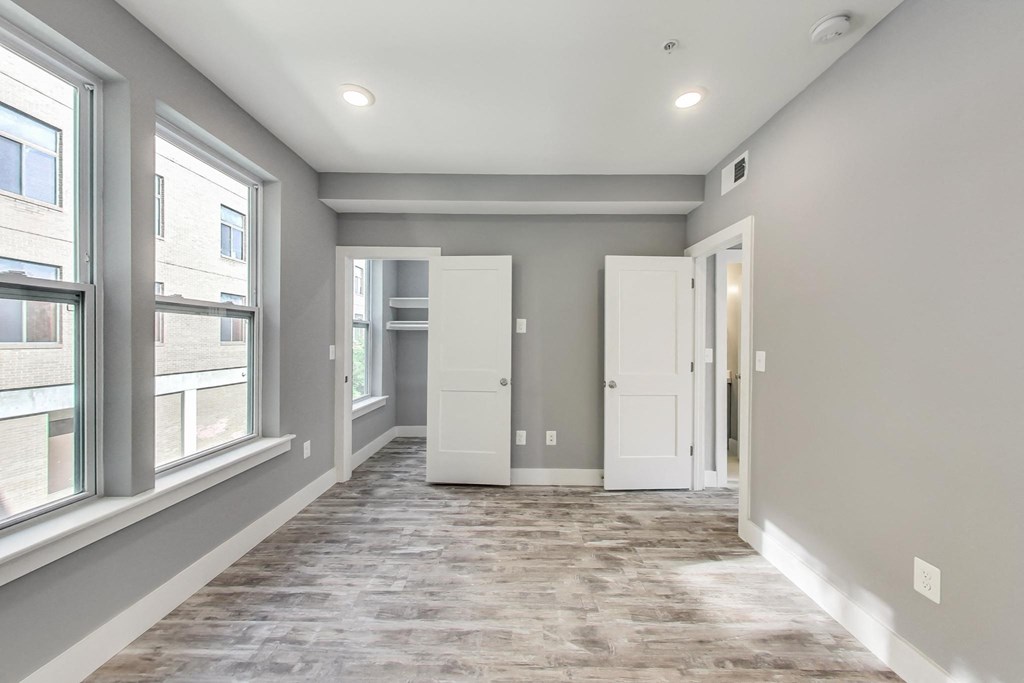 a newly renovated living room with windows and a door