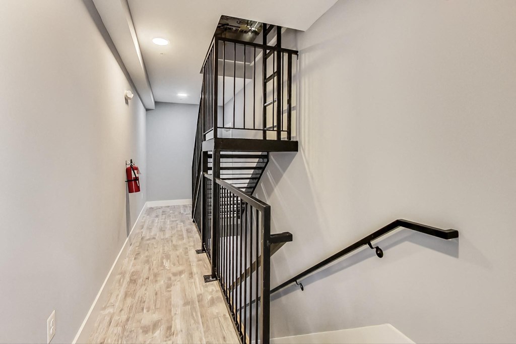 the stairwell in a new home with white walls and wood floors