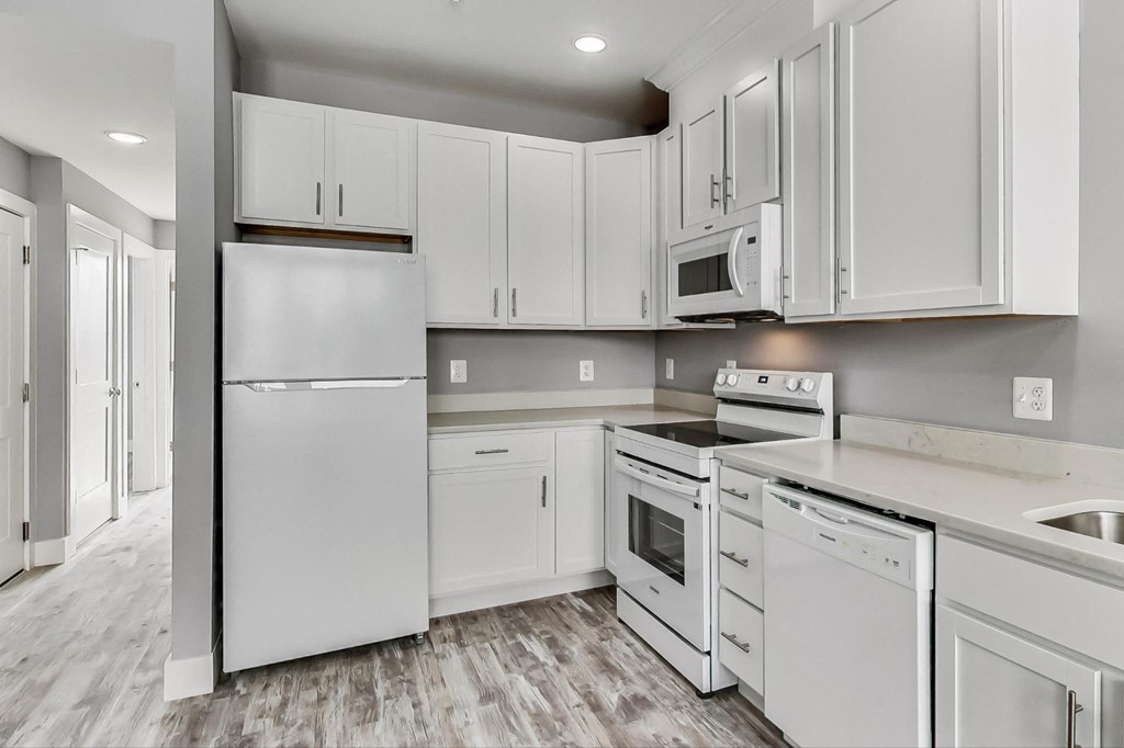 the kitchen of a home with white cabinets and stainless steel appliances