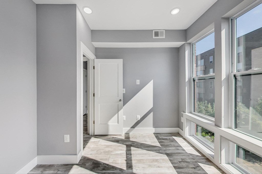 an empty living room with large windows and a door