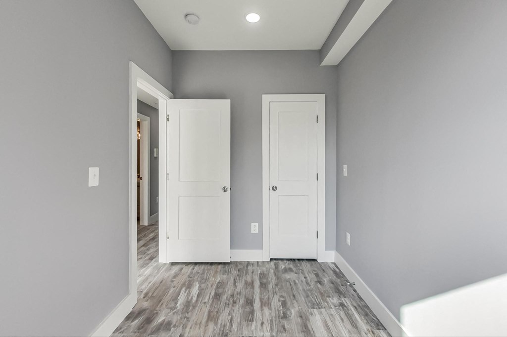 a room with grey walls and white doors and a door to a closet