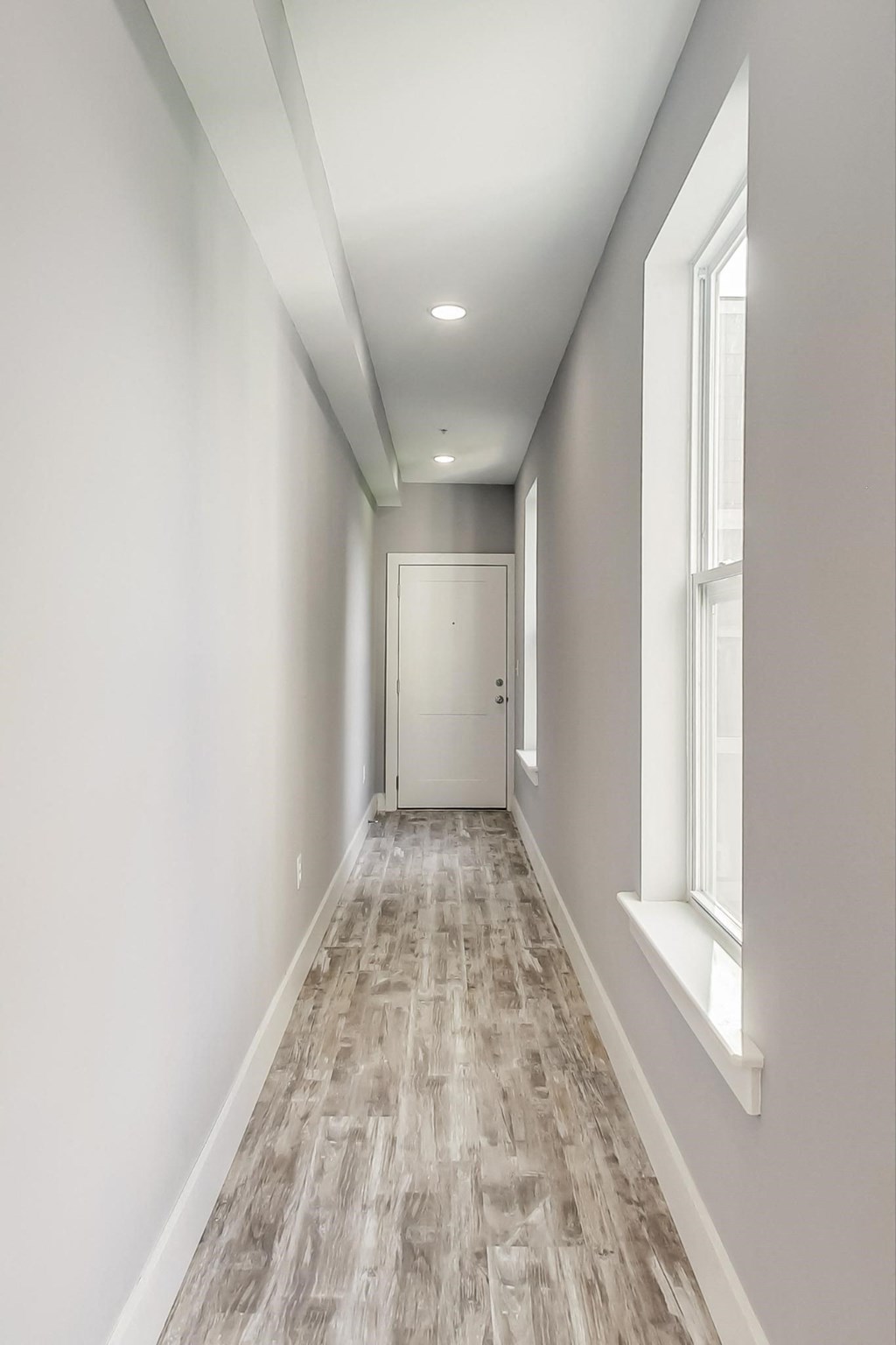 a newly renovated corridor with white walls and wood floors