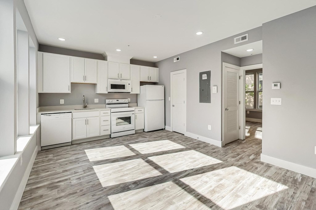 a large kitchen with white cabinets and white appliances