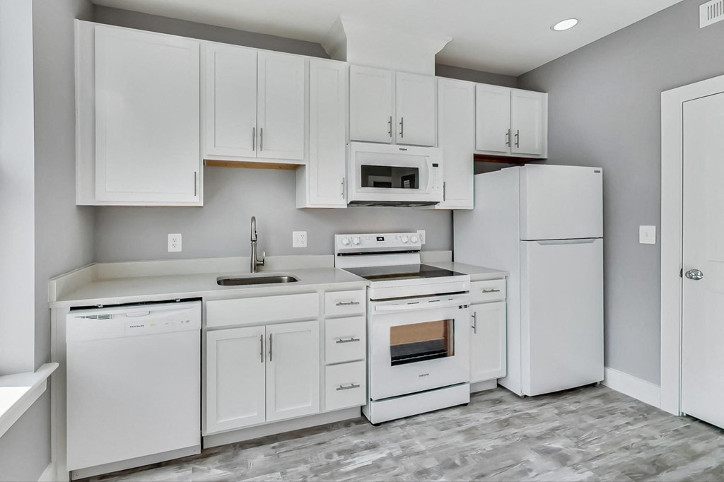 a white kitchen with white appliances and white cabinets