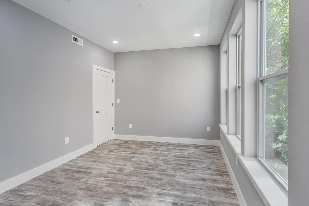 an empty room with a large window and a door