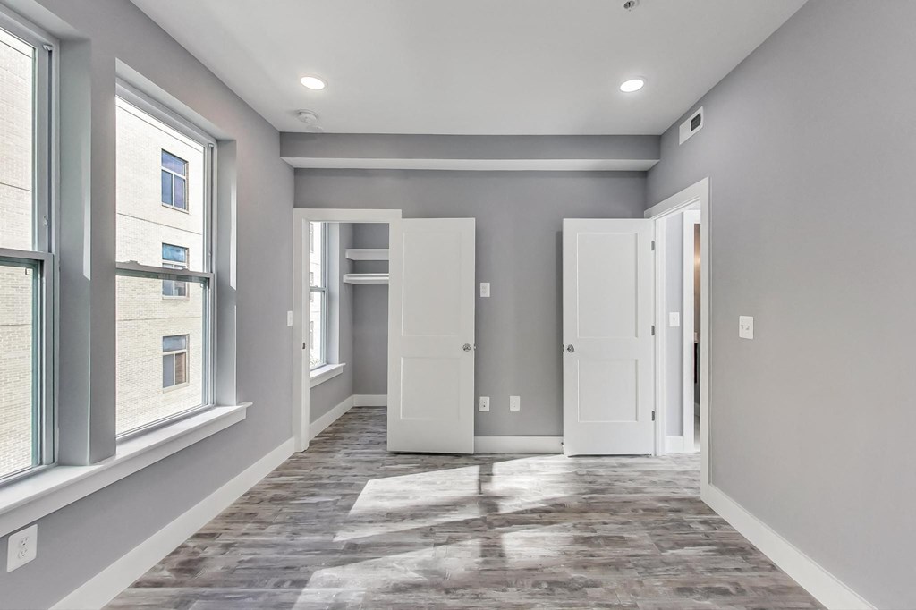 an empty room with two doors and a window