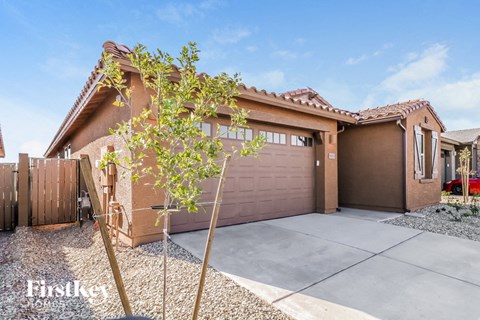 a home with a garage door and a tree in front of it