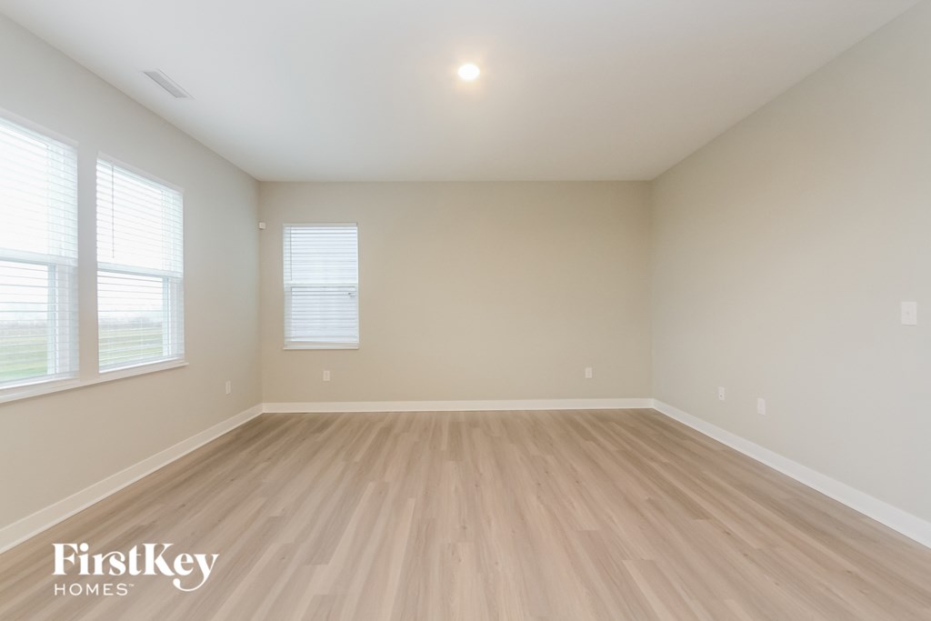 A room with wooden flooring and a window.