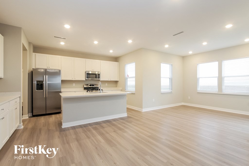 A kitchen with a refrigerator, microwave, and oven.