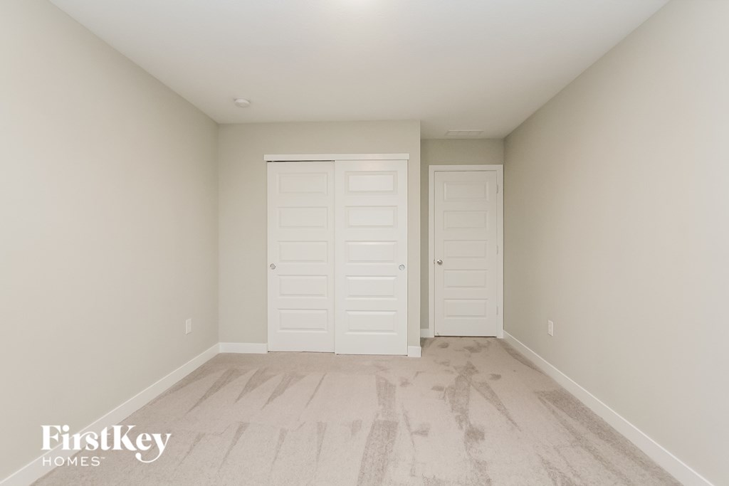 A room with two white doors and a wooden floor.