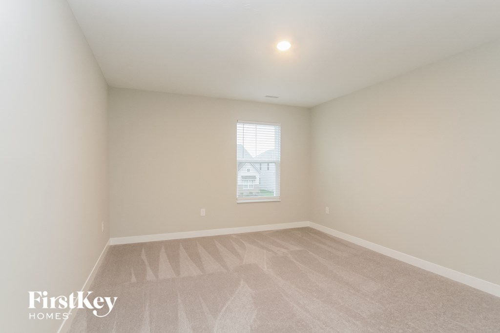 A room with a window and a carpet on the floor.
