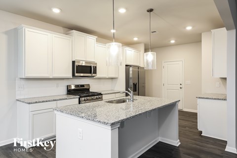 A modern kitchen with granite countertops and stainless steel appliances.
