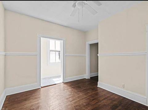 an empty living room with wood floors and white walls