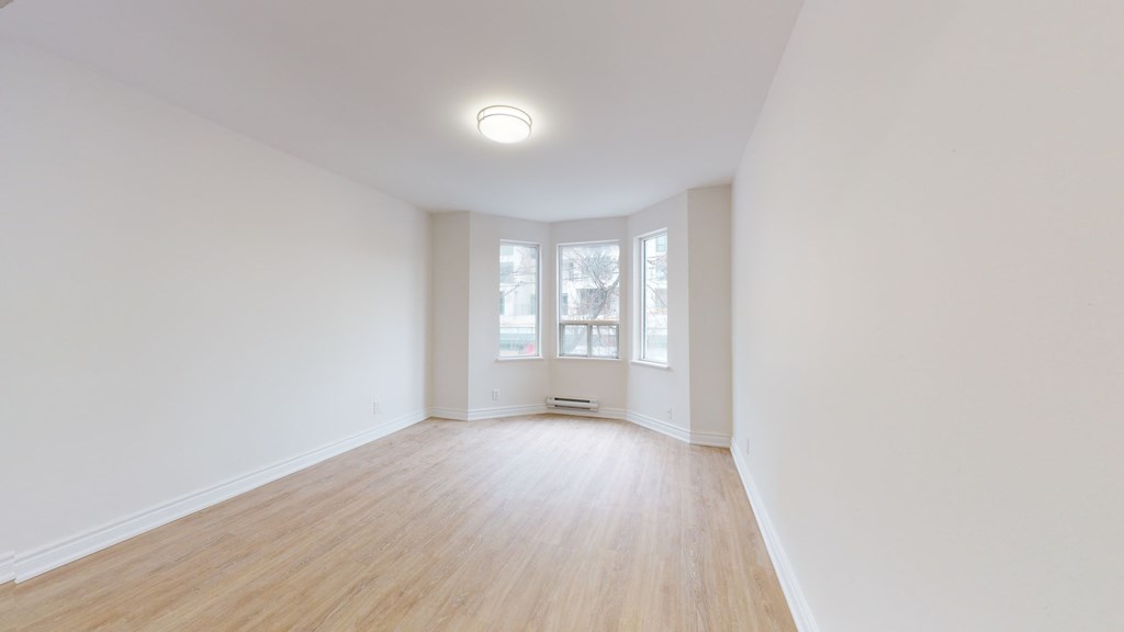 an empty living room with white walls and wood floors