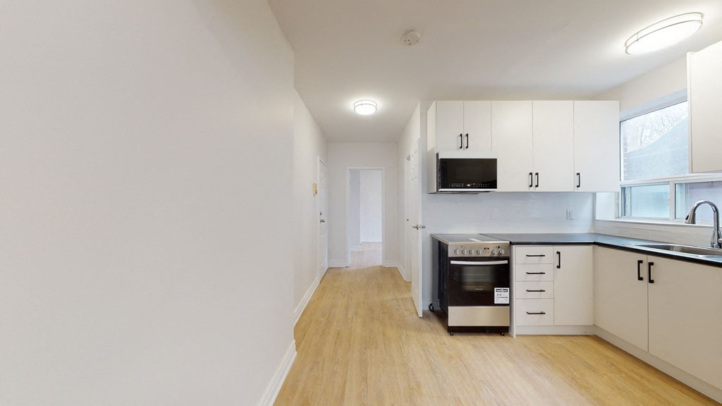 a kitchen with white cabinets and a stove and a microwave