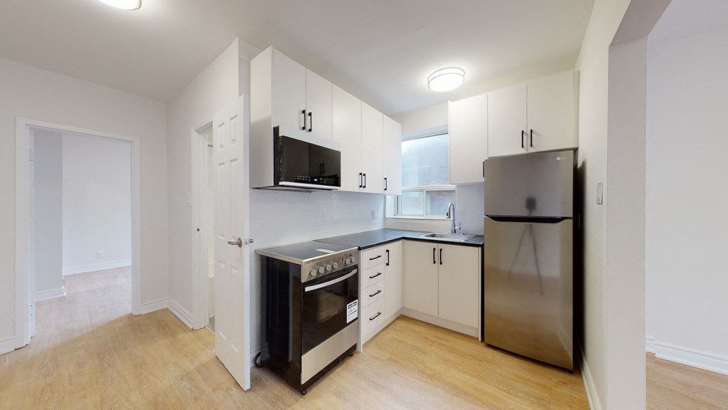 a kitchen with white cabinets and a stainless steel refrigerator and stove