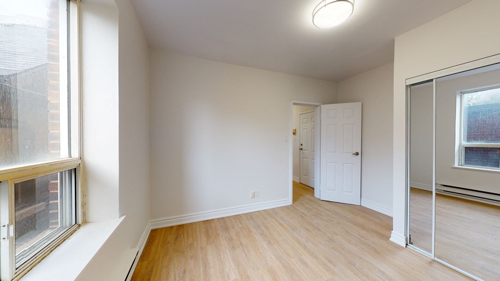 an empty living room with a large window and a door