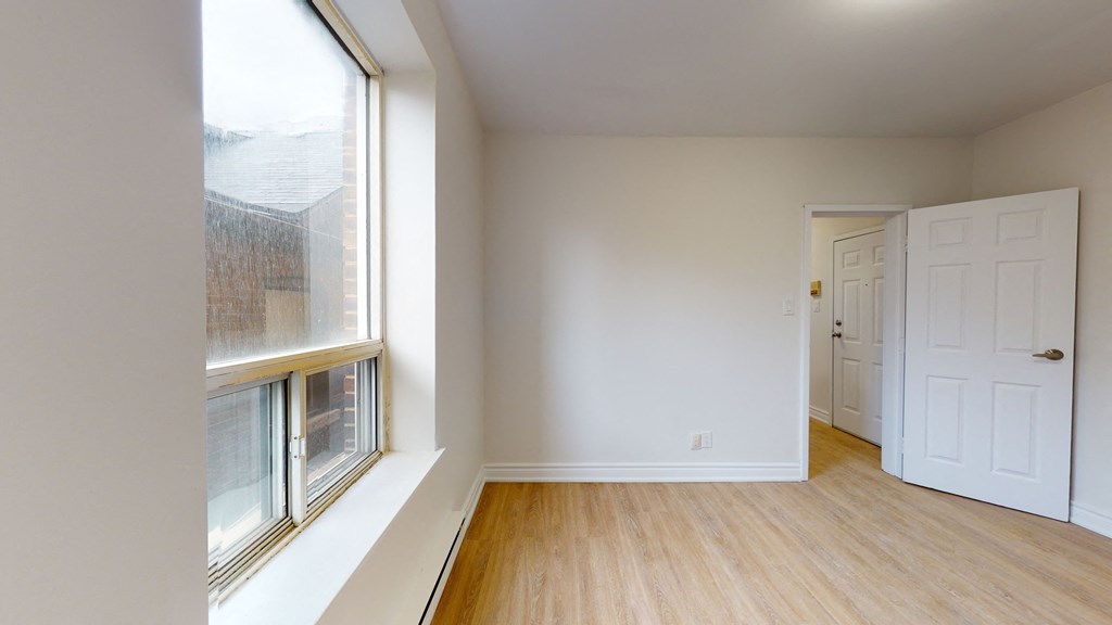 an empty room with a large window and a door