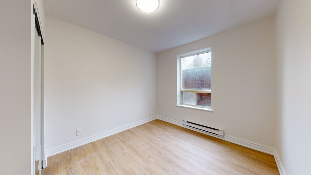 an empty room with white walls and a window