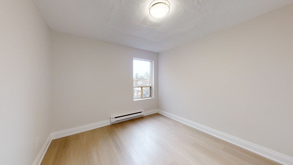 an empty room with white walls and a window