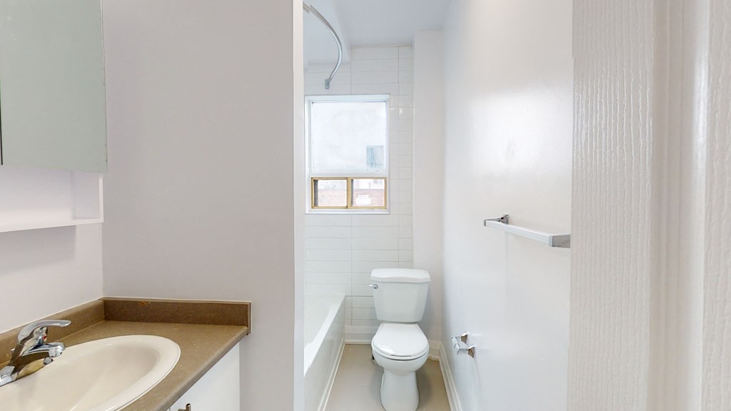 a bathroom with a toilet and a sink and a window