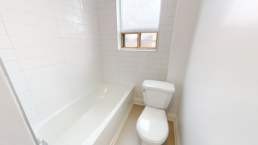 an empty bathroom with a toilet and a tub