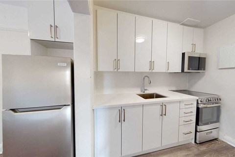 a kitchen with white cabinets and a stainless steel refrigerator