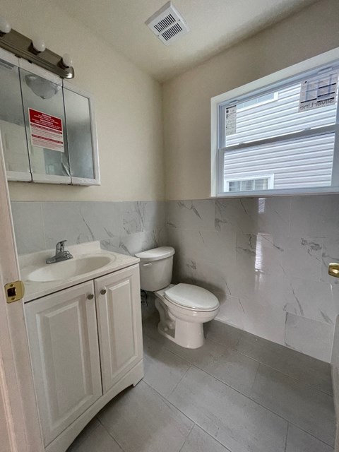 a bathroom with a toilet and a sink and a window