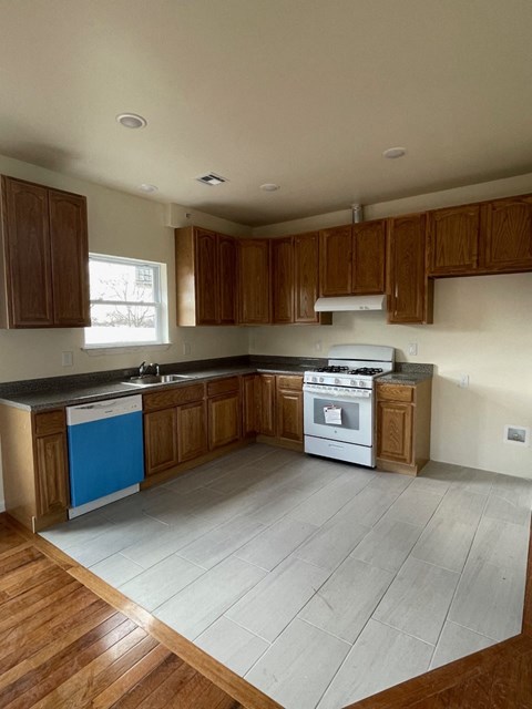 an empty kitchen with wooden cabinets and a stove