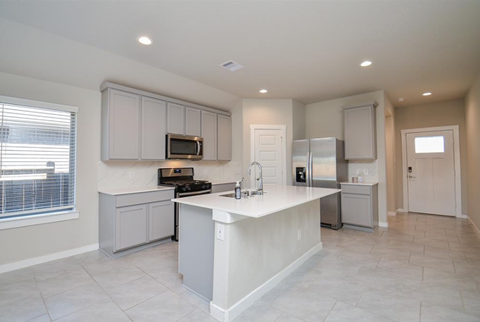 A kitchen with a white countertop and grey cabinets.