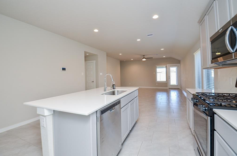 A modern kitchen with white cabinets and a white island.