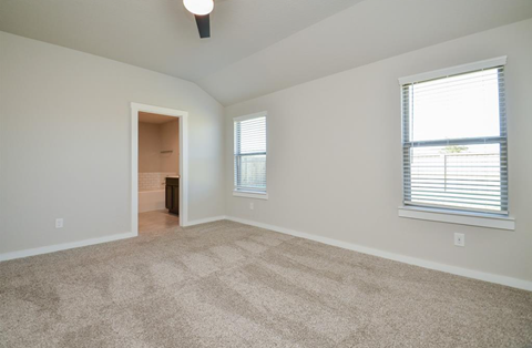 A room with a carpeted floor and a window with blinds.