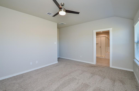 A room with a ceiling fan and carpeted floor.