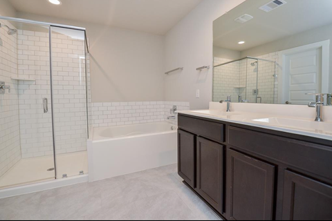 A white bathroom with a walk-in shower and a white bathtub.