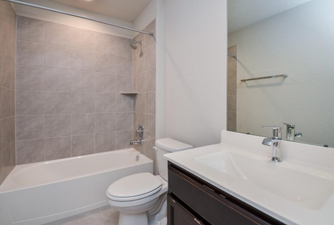A white toilet sits next to a white sink in a bathroom.