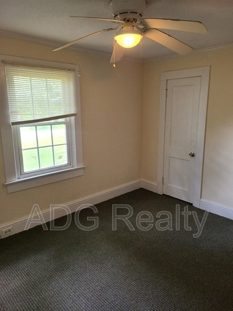 a small bedroom with a ceiling fan and a window