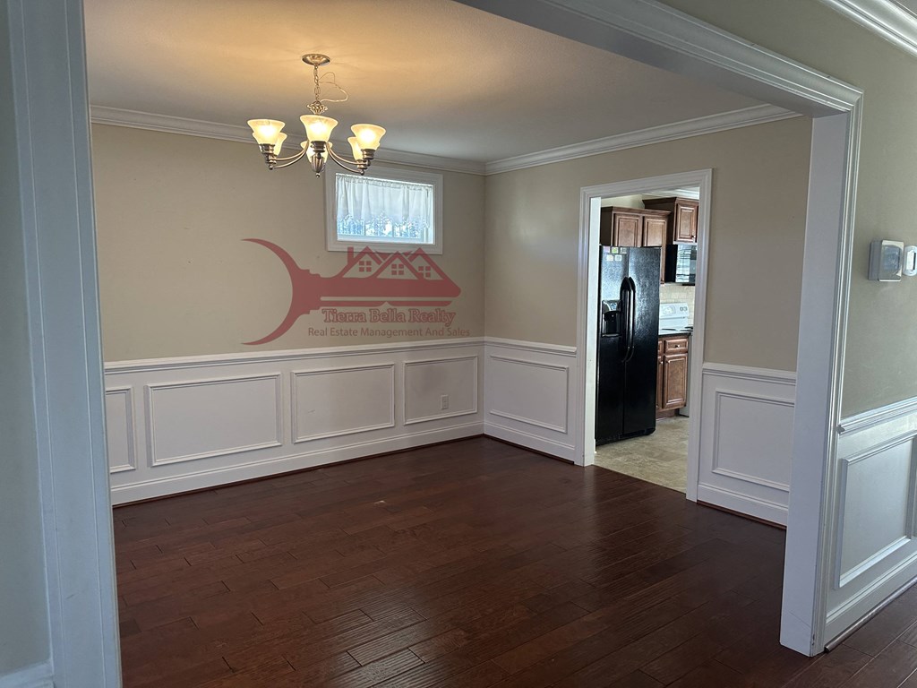 a dining room with white walls and a wood floor