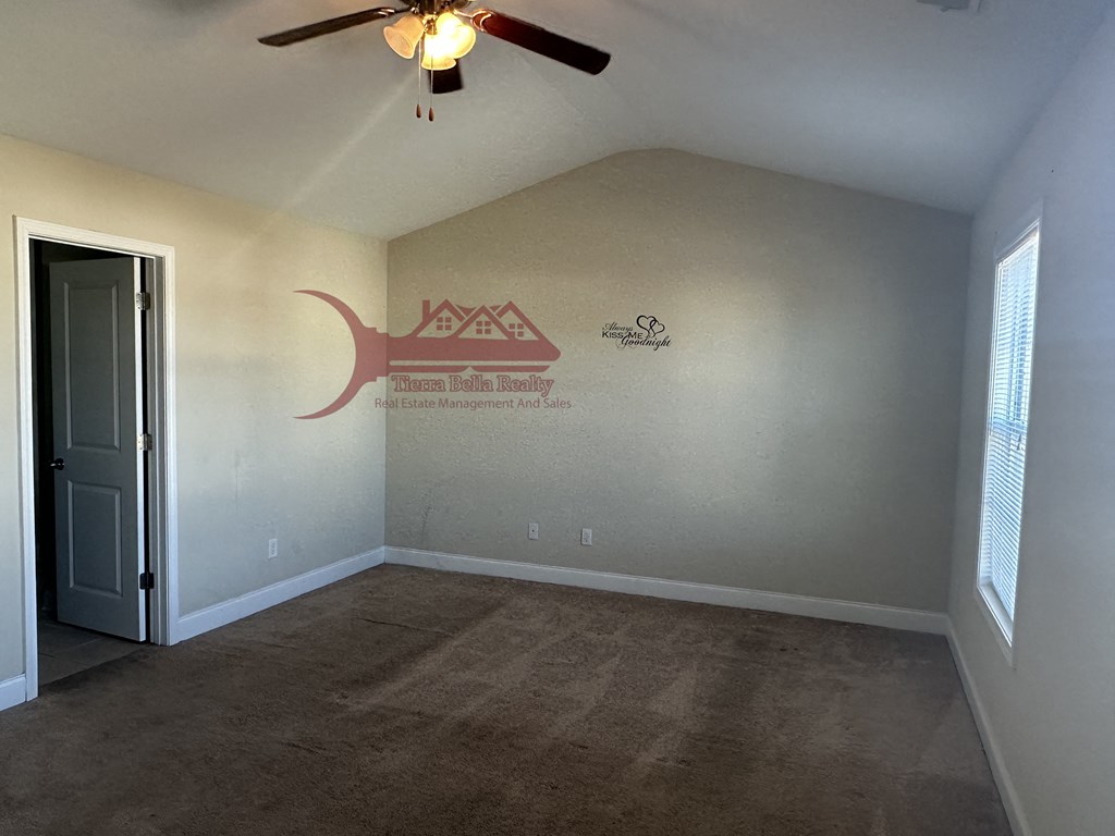 an empty room with a ceiling fan and a door