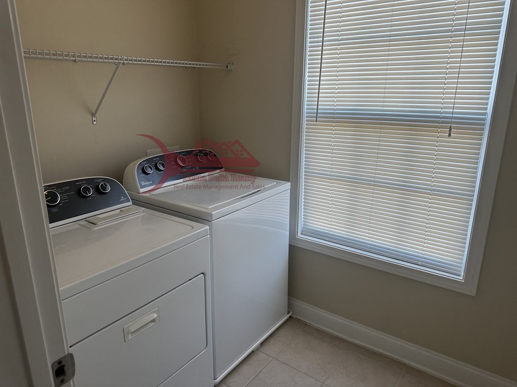 a laundry room with a washer and dryer and a window