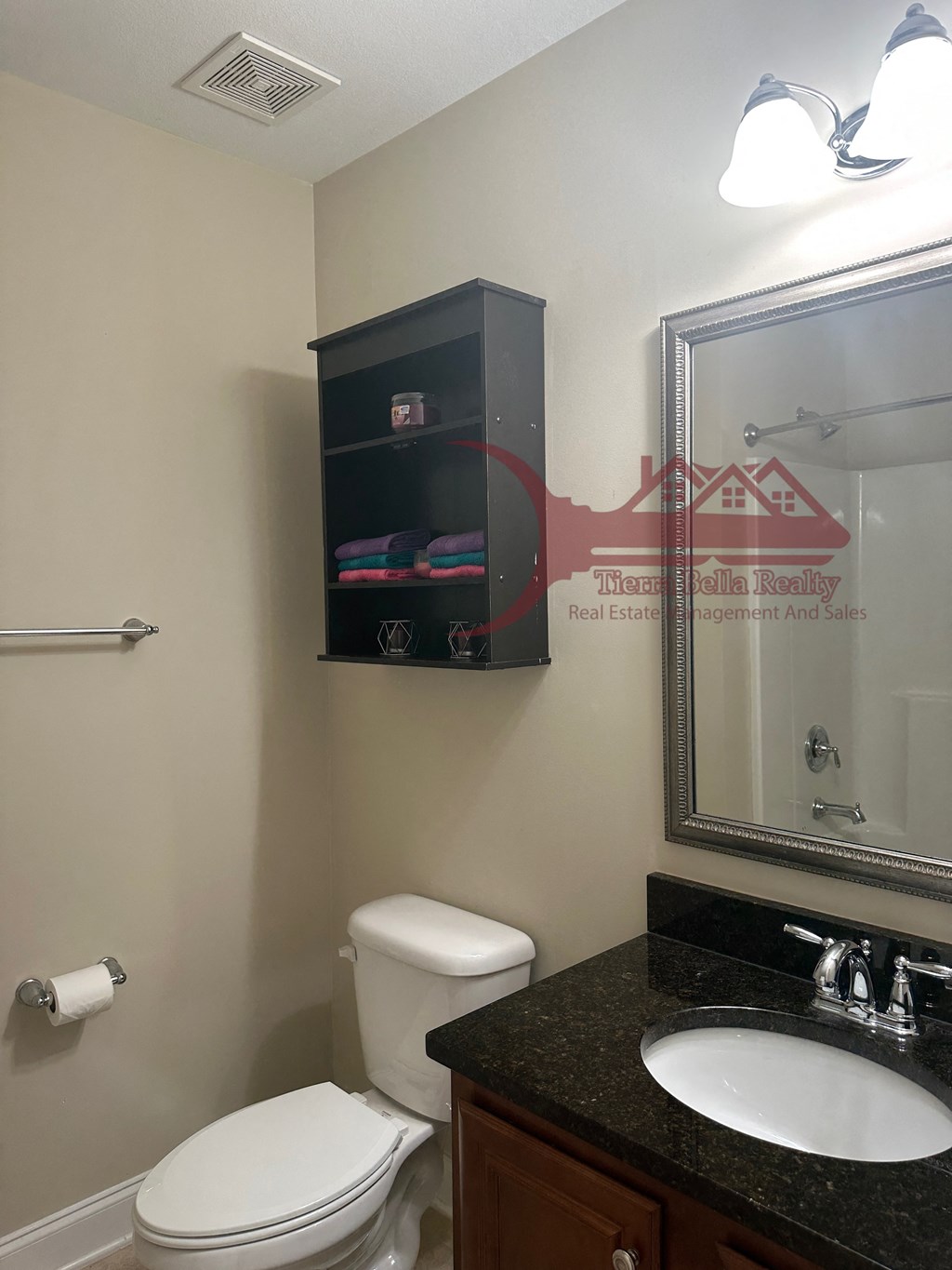 a bathroom with a toilet sink and mirror and a mirror above a sink and toilet