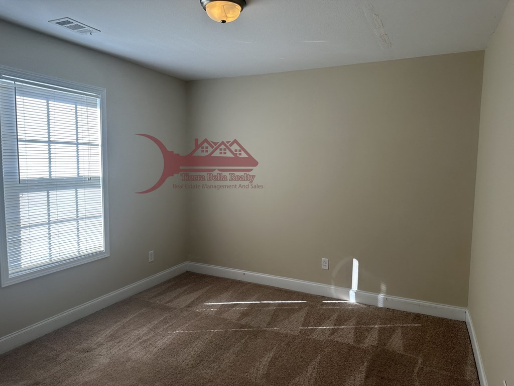 an empty room with a large window and a vinyl floor