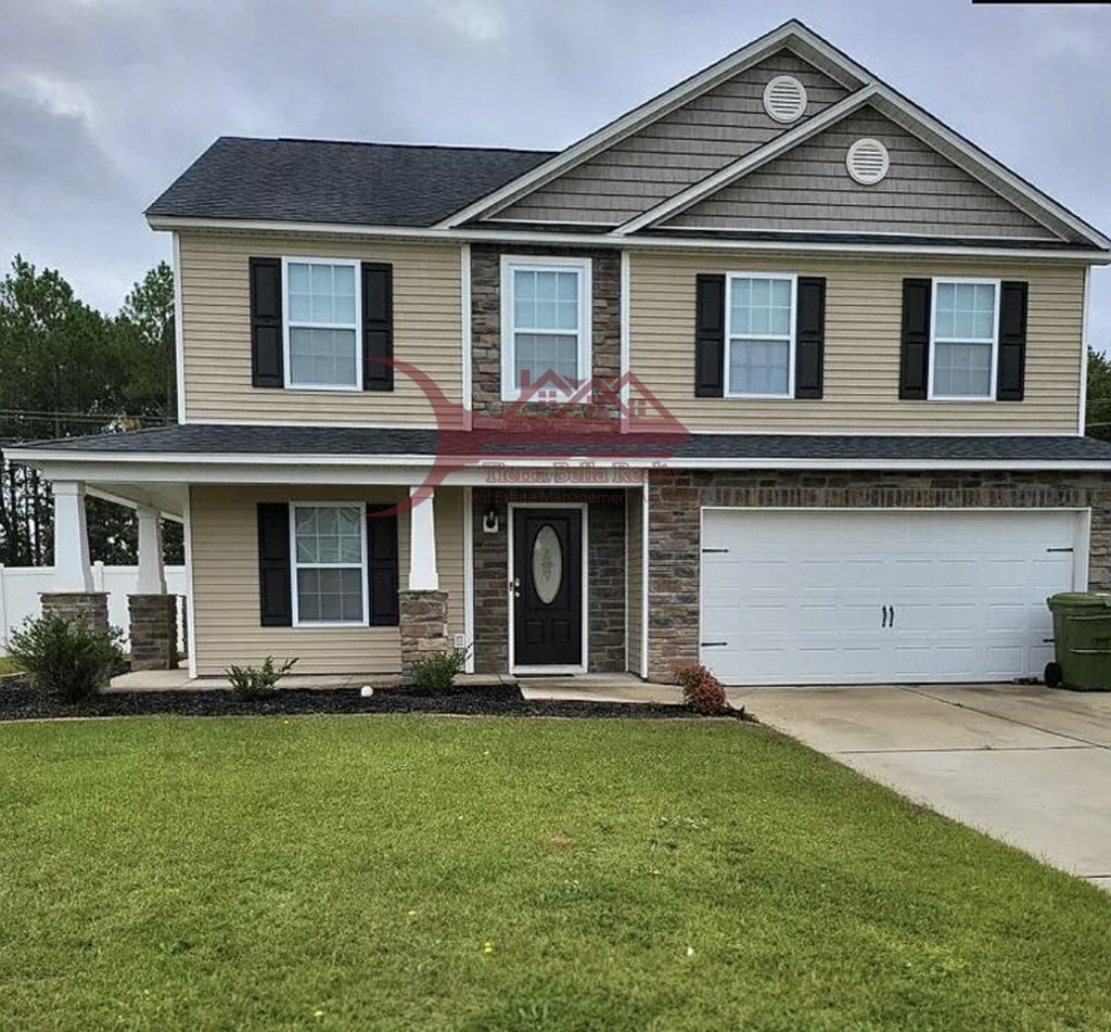 a tan house with black shutters and a white garage door