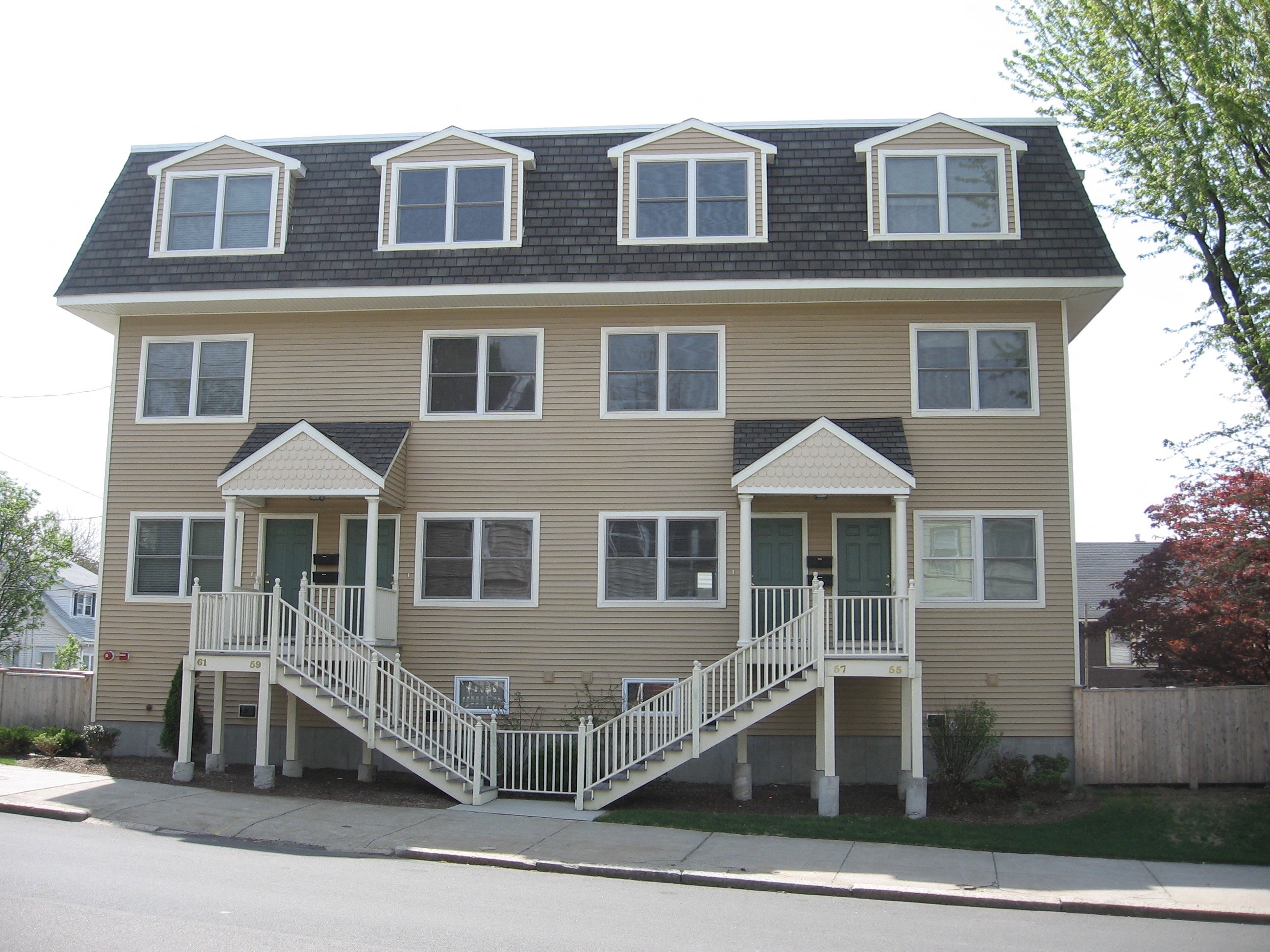 a yellow house with a front porch and stairs