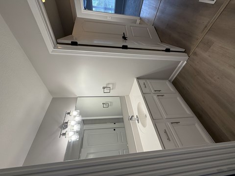 A white door is in a room with a skylight.