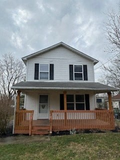 a white house with a porch on a cloudy day
