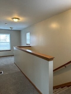 an empty living room with a white wall and a staircase