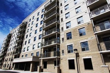 A large apartment building with balconies and multiple windows.