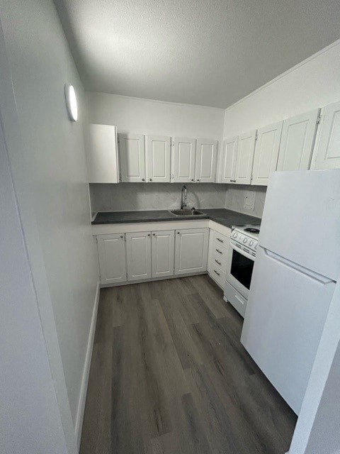 a white kitchen with white appliances and white cabinets