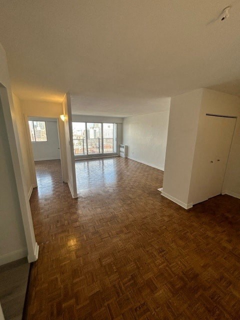 an empty living room with a hard wood floor